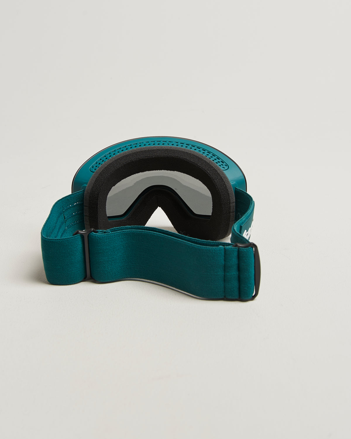 Green ski goggles with blue lens from behind