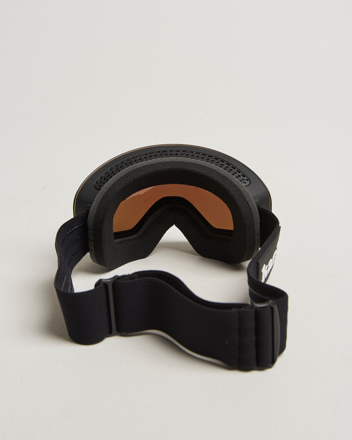 Black ski goggles with bronze lens from behind