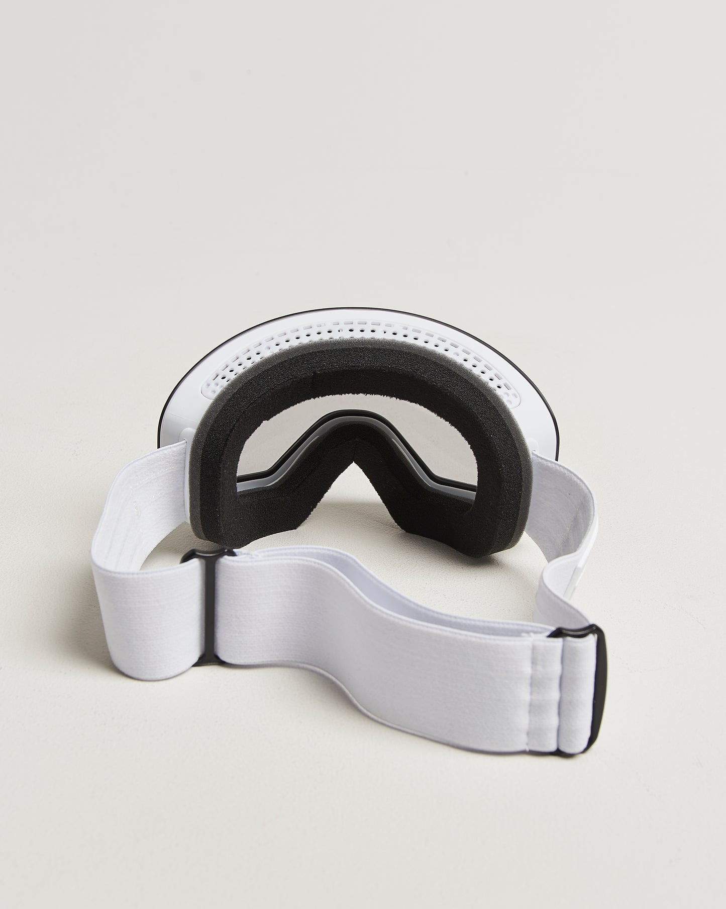 White ski goggles with photochromic lens from behind