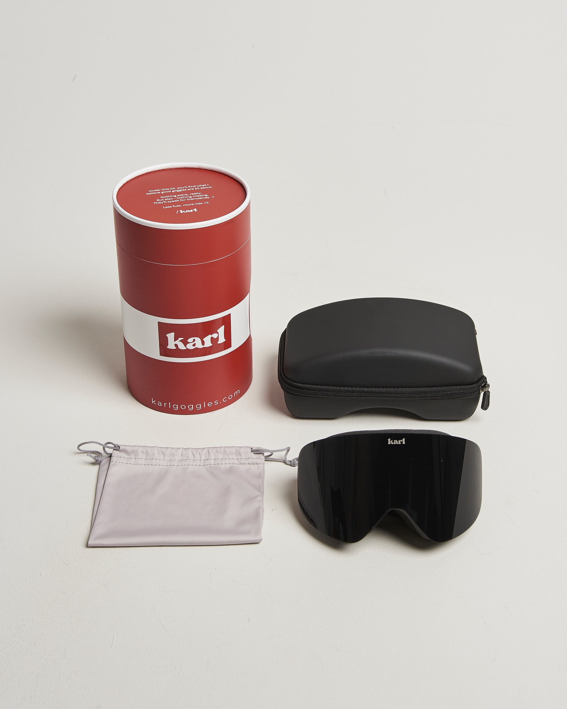 Karl goggles set with red cylindrical box, black case, and gray cleaning cloth.