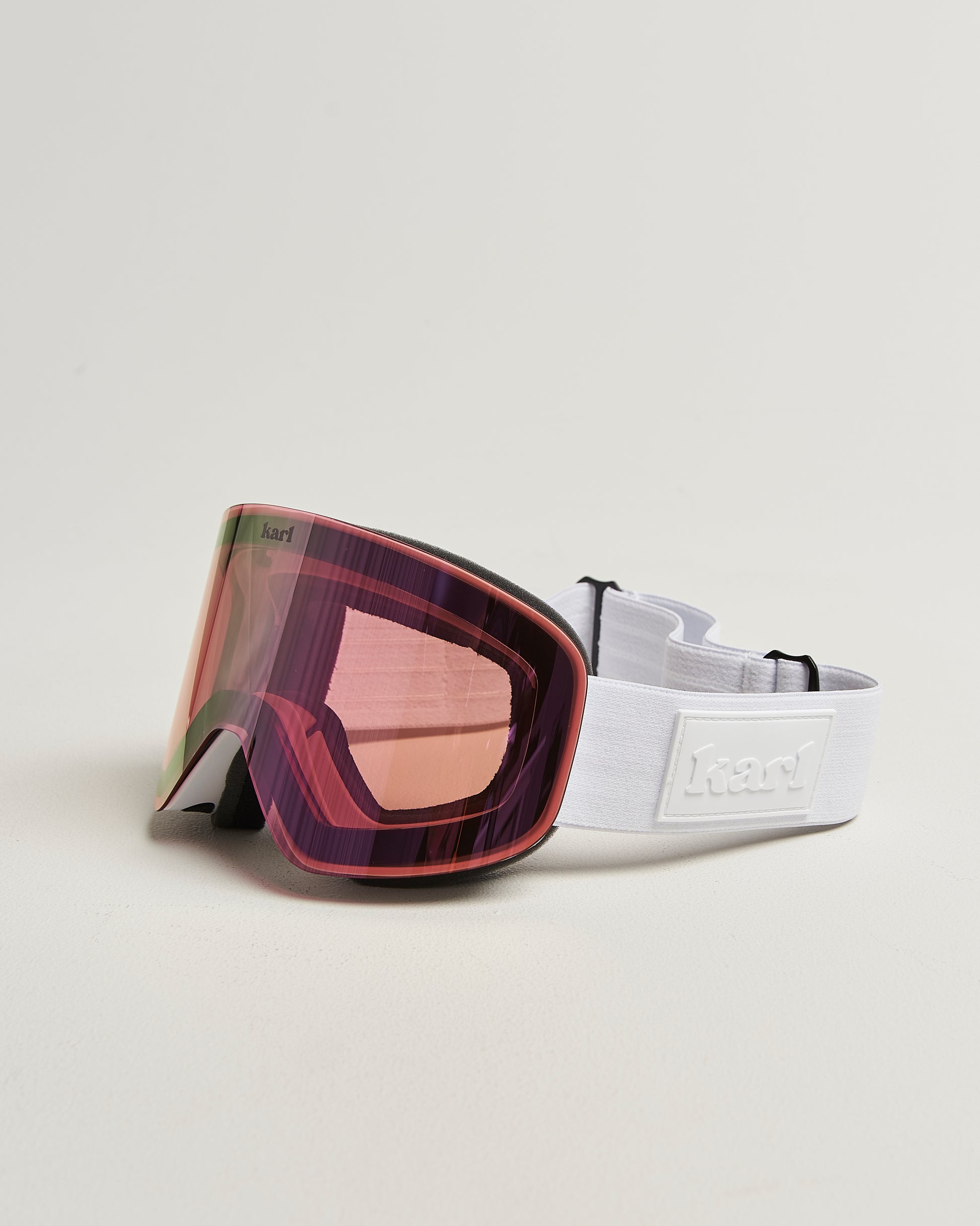White ski goggles with pink lens side view